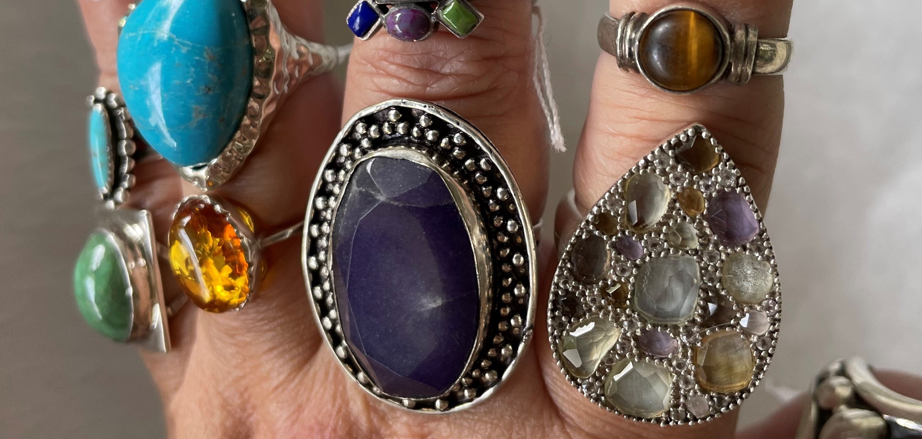 A big selection of gemstone rings on one hand. Many types of rings for the jewelry lover.
